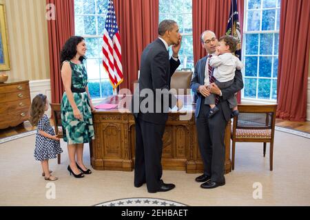 Le président Barack Obama embrasse Oren Baer, fils de Ken Baer, le directeur associé sortant pour la communication et la planification stratégique à l'OMB, lors d'une visite au Bureau ovale, le 12 juillet 2012. La fille de Baer, Avital, et la femme, Caron Gremont, regardent à gauche. Banque D'Images