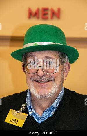 3-5-2019 Tulsa USA - homme âgé avec un sourire mignon et la barbe et les lunettes sont en service aux caisses dans le rayon de port de l'épicerie Nom tag-Jim-et leprechaun chapeau Banque D'Images