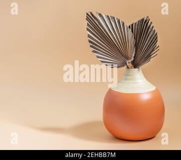 Feuilles de palmier à sucre tropical sèches dans un vase moderne original sur fond pastel neutre. Détails intérieurs pour vos besoins, espace de copie pour votre texte. Banque D'Images
