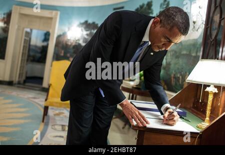 Le président Barack Obama signe H.R. 152, qui fournit des crédits supplémentaires pour l'exercice 2013 pour répondre aux graves dommages causés par l'ouragan Sandy et les récupérer, dans la salle de réception diplomatique de la Maison Blanche, le 29 janvier 2013. Banque D'Images