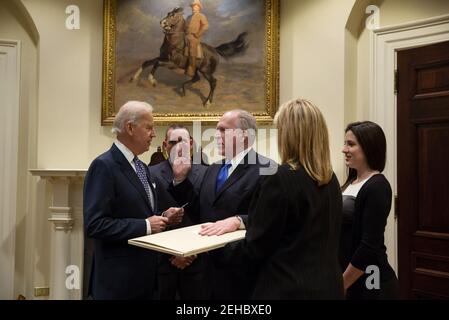 Le vice-président Joe Biden a jure dans le directeur de la CIA John Brennan dans la salle Roosevelt de la Maison Blanche, le 8 mars 2013. Brennan a prêté serment avec sa main sur un projet original de la Constitution qui a l'écriture personnelle de George Washington et des annotations sur elle, datant de 1787. Les membres de la famille de Brennan se tiennent avec lui. Banque D'Images