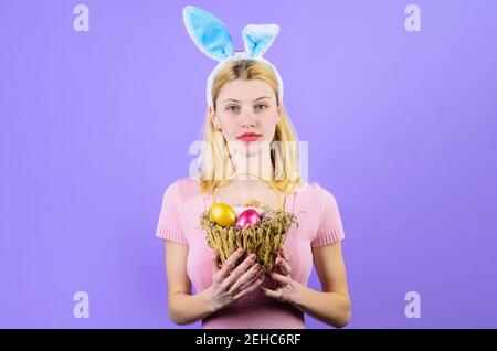 Le jour de Pâques. Femme avec œufs en panier. Fille de lapin. Chasse aux œufs. Banque D'Images