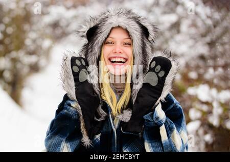 Vacances d'hiver. Bonne jeune femme en hiver. Fille souriante dans un parc à neige. Belle femme en manteau chaud et chapeau en fourrure. L'hiver. Banque D'Images