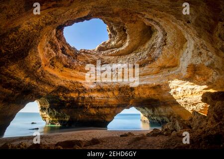 Vue panoramique de la grotte de Benagil avec trous sur la rive contre Océan infini en Algarve Portugal Banque D'Images