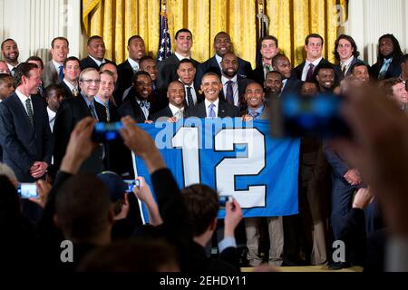 Le président américain Barack Obama soutient une 12ième homme drapeau comme il pose pour une photo de groupe avec le Super Bowl Champion Seattle Seahawks lors d'un événement en l'honneur de l'équipe et leur Super Bowl XLVIII la victoire, dans l'East Room, le 21 mai 2014. Banque D'Images