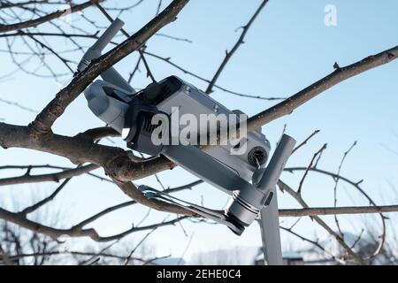 Rupture de la caméra de nacelle et du bras du moteur du drone après un accident gros plan des branches de l'arbre Banque D'Images