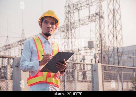 Ingénieur vérifiant le système de sécurité en usine à l'extérieur, technicien portant un casque de sécurité sur le lieu de travail Banque D'Images