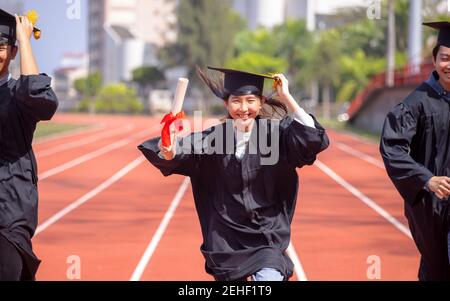 heureux étudiants de remise des diplômes et de course au stade à l'école Banque D'Images