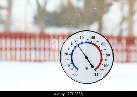 Thermomètre indiquant la température froide pendant la tempête de neige hivernale. Concept du temps de congélation, de la température froide et de la sécurité hivernale Banque D'Images
