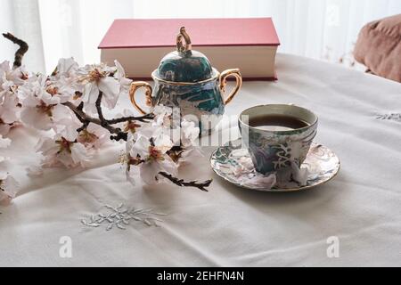 Encore la vie d'un livre, des tasses de café et des fleurs d'amande. Lecture c Banque D'Images