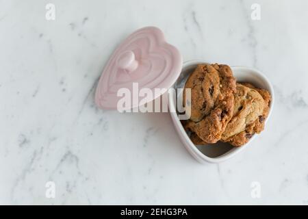 Petits gâteaux aux pépites de chocolat frais dans un plat de Saint-Valentin Banque D'Images