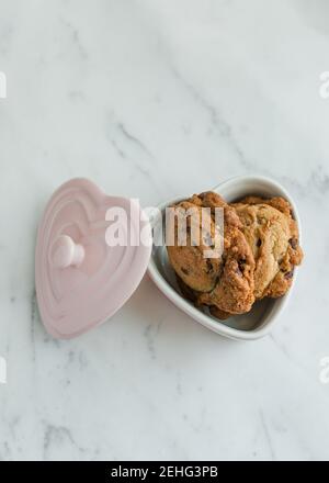 Petits gâteaux aux pépites de chocolat frais dans un plat de Saint-Valentin Banque D'Images