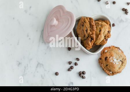 Petits gâteaux aux pépites de chocolat frais dans un plat de Saint-Valentin Banque D'Images