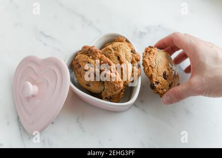 Petits gâteaux aux pépites de chocolat frais dans un plat de Saint-Valentin Banque D'Images