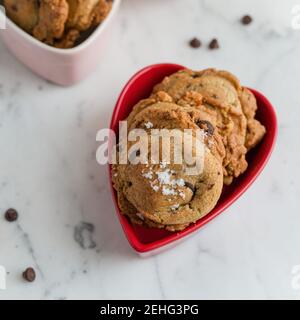 Petits gâteaux aux pépites de chocolat frais dans un plat de Saint-Valentin Banque D'Images