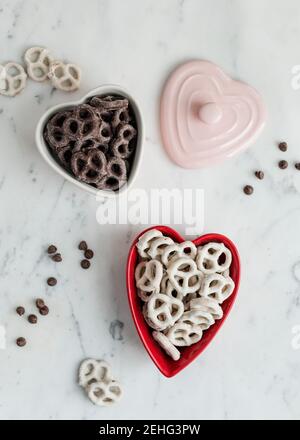 Bretzels croustillants enrobés de chocolat dans un plat de Saint-Valentin en forme de coeur Banque D'Images