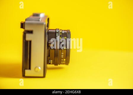 Vintage très ancien appareil photo film tourné en studio, fond jaune. Banque D'Images