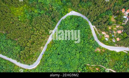 Vue aérienne de route sinueuse à travers la forêt dense sur la haute montagne en Bulgarie. Banque D'Images