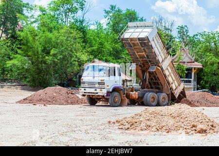 Le camion-benne descend le sol sur le chantier. Banque D'Images