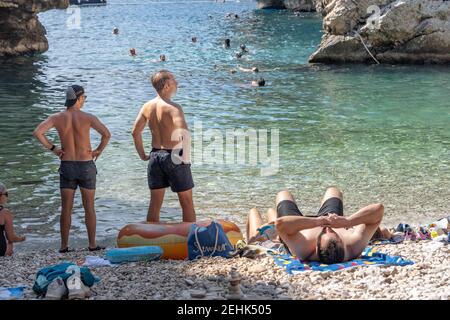 Vis, Croatie - 17 août 2020 : les touristes se bronzent sur la plage abritée de Stiniva en été Banque D'Images