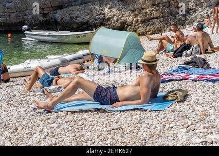 Vis, Croatie - 17 août 2020 : les touristes se bronzent sur la plage abritée de Stiniva en été Banque D'Images