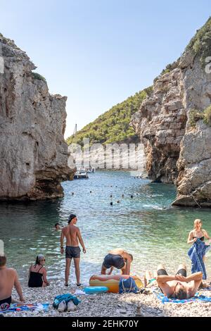 Vis, Croatie - 17 août 2020 : les touristes se bronzent sur la plage abritée de Stiniva en été Banque D'Images