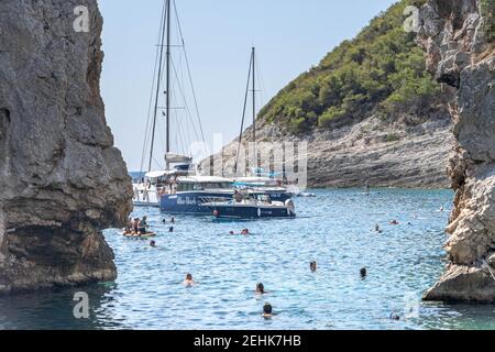 Vis, Croatie - 17 août 2020 : les gens nagent à l'entrée de la plage abritée de stiniva en été Banque D'Images