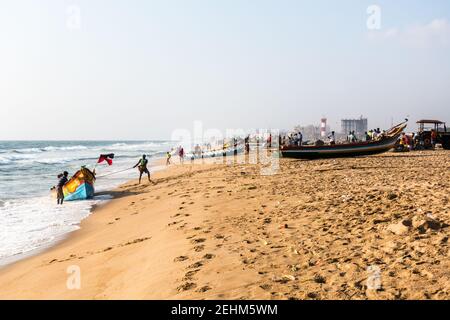 Pêcheur poussant le bateau à la terre de la mer après le retour le travail de jour Banque D'Images
