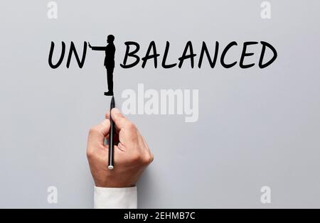 Main d'homme d'affaires dessinant une silhouette d'un homme changeant le mot déséquilibré à équilibré en poussant les lettres. Trouver le point d'équilibre dans busi Banque D'Images