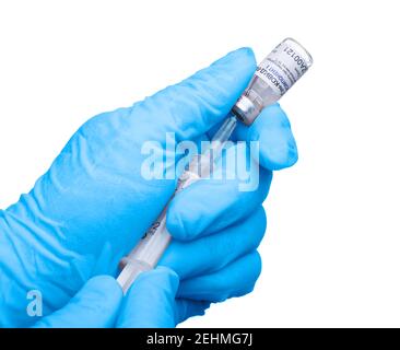 Moscou, Russie – 10 février 2021 : les mains en gants bleus attirent le vaccin Spoutnik V Gam-COVID-Vac dans une seringue à partir d'un flacon. Isolé sur ba blanc Banque D'Images