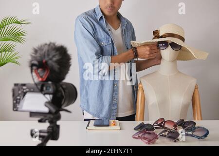 L'asiatique vlogger ou Blogger porter des lunettes de mode noires aux mannequins pour montrer le client et la vidéo d'enregistrement. Freelance Online Streaming avec le client Banque D'Images
