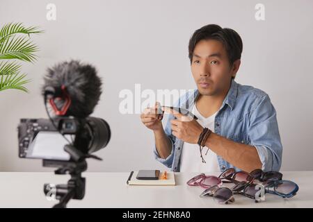 Frontal asiatique vlogger ou Blogger dans Jean chemises examen mode verres par enregistrement vidéo. Freelance Online Streaming avec le client via social Med Banque D'Images
