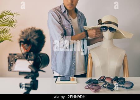 L'asiatique vlogger ou Blogger porter des lunettes de mode noires aux mannequins pour montrer le client et la vidéo d'enregistrement. Freelance Online Streaming avec le client Banque D'Images