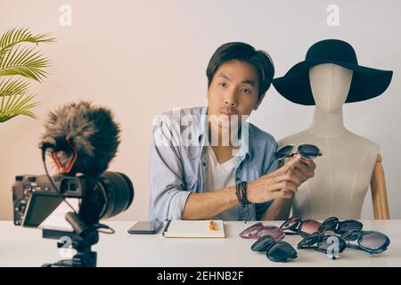Vlogger asiatique ou Blogger en Jean chemises avec mannequins examen de mode lunettes et enregistrement vidéo. Freelance Online Streaming avec le client via Banque D'Images