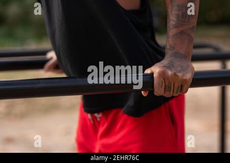 l'athlète afro-américain garçon fait des exercices de mise en forme calisthéniques dans les bars dans le parc Banque D'Images