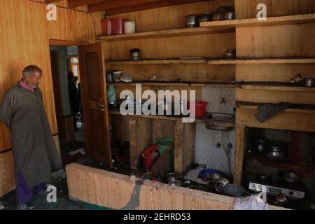 Budgam, Inde. 19 février 2021. Un homme qui inspecte la maison a été endommagé lors d'une rencontre entre des meuniers et des forces dans la région de beerwah, dans le district de Budgam, le 19-02-2021. Lors de la rencontre, un policier a été tué et un autre blessé. (Photo de Muhammad Manan/Pacific Press) crédit: Pacific Press Media production Corp./Alay Live News Banque D'Images