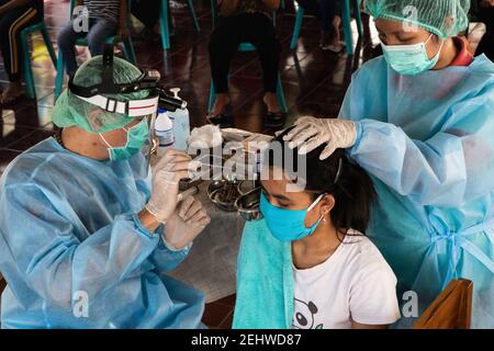 BALI/INDONESIA-DEC 3 2020: Deux médecins bénévoles qui effectuent des examens d'oreille dans un orphelinat de Bali. Pendant la pandémie de Covid-19, les examens de l'oreille doivent b Banque D'Images