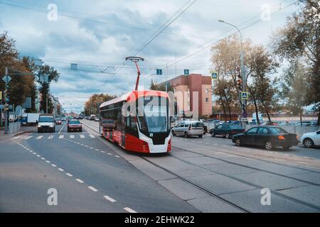 Tramway moderne rouge et blanc dans la rue de Perm, en Russie. Nouveaux tramways pour les villes russes. Banque D'Images