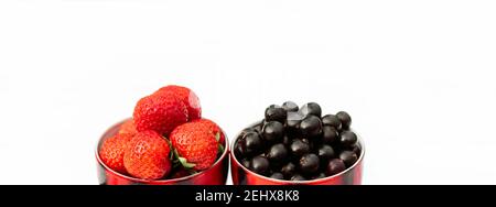 fraises et raisins de corinthe noirs dans une tasse, concept été dans le village Banque D'Images