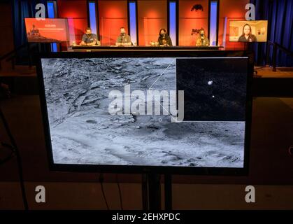 Une image montrant le stade de descente qui maintient le rover de la persévérance de la NASA peut être vu tomber à travers l'atmosphère martienne, son parachute traînant derrière, dans cette image prise le 18 février 2021, Par la caméra HiRISE (High Resolution Imaging Experiment) à bord de l'orbiteur de reconnaissance Mars est présenté lors d'un briefing de vérification de surface initial de la NASA, le vendredi 19 février 2021, au Jet propulsion Laboratory de la NASA à Pasadena, en Californie. L'ancien delta du fleuve, qui est la cible de la mission de persévérance, peut être vu entrer dans le cratère de Jezero de la gauche. Un objectif clé pour Perever Banque D'Images