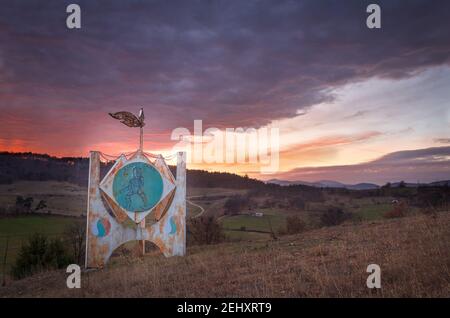 Le lever du soleil rouge et orange vif à l'aube reflète le monument du guerrier Banque D'Images