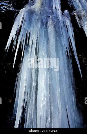 Plan vertical de grandes icicles accrochés sur une falaise élevée Banque D'Images