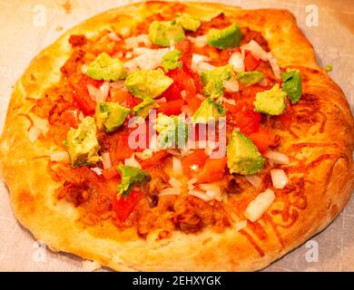 Gros plan sur une pizza mexicaine maison avec avocat sur le dessus. Banque D'Images