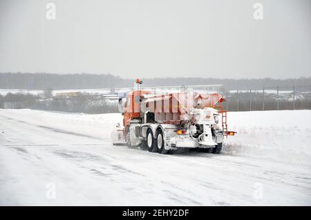 Nettoyer la route des accumulations de neige à l'aide d'un équipement routier spécialisé. Banque D'Images