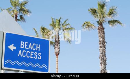 Panneau de plage et palmiers dans la Californie ensoleillée, États-Unis. Palmiers et panneau de bord de mer. Esthétique de la station touristique Oceanside pacific. Symbole des vacances de voyage Banque D'Images