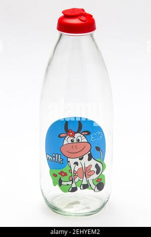 Une bouteille de lait en verre vide rétro avec une vache Dessin sur elle et un capuchon en plastique rouge Banque D'Images