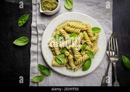 Pâtes italiennes Fussili au pesto de basilic et au basilic frais sur fond noir. Vue de dessus. Banque D'Images