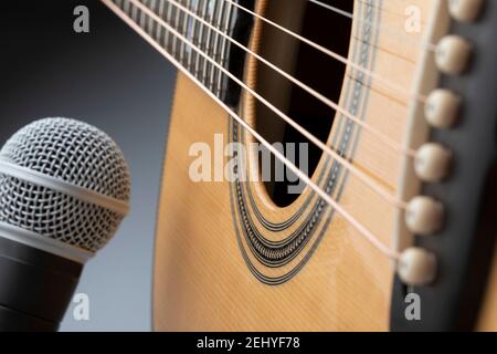 Corps de guitare acoustique avec microphone sur fond gris Banque D'Images