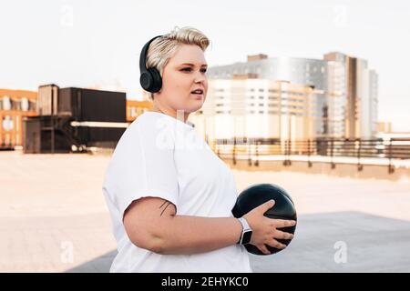 Jeune femme portant un casque d'exercice avec un medecine ball Banque D'Images