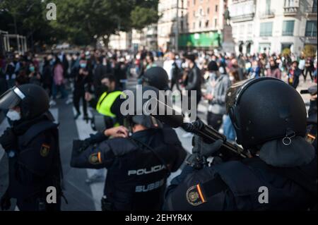 Malaga, Espagne. 20 février 2021. Une police anti-émeute tenant un fusil de chasse comme un manifestant marche pendant la manifestation. Pablo Hasel, chanteur de rappeurs, a été condamné pour avoir glorifié le terrorisme et insulté la couronne espagnole et les institutions de l'État par ses chansons et ses tweets. De fortes émeutes ont éclaté dans plusieurs villes après son incarcération au cours des derniers jours, comme une réponse en faveur de la liberté d'expression. Crédit : SOPA Images Limited/Alamy Live News Banque D'Images